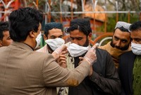 Tình nguyện viên Afghanistan phát khẩu trang tại Herat, nằm sát biên giới Iran ngày 26/2. Ảnh: AFP.