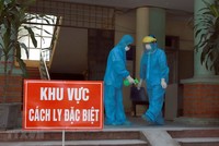 Các y bác sỹ Phòng khám Đa khoa khu vực Quang Hà mặc đồ bảo hộ và xịt nước xát khuẩn khi làm việc tại khu vực cách ly. (Ảnh: Hoàng Hùng/TTXVN).