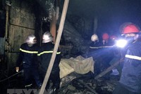 Lực lượng chức năng đã tiếp cận được nạn nhân trong vụ cháy. (Ảnh: Công Tường/TTXVN).