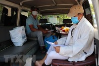 Bệnh nhân nhận và kiểm tra giấy chứng nhận ra viện. (Ảnh: Nguyễn Thành/TTXVN).