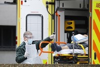 Nhân viên y tế chuyển một bệnh nhân nghi nhiễm nCoV xuống khỏi xe cứu thương tại St Thomas ở London ngày 31/3. Ảnh: AFP.