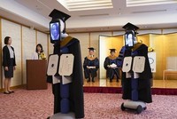 Các robot được mặc trang phục tốt nghiệp và gắn một chiếc máy tính bảng trên mặt.