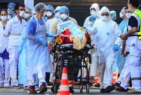 Nhân viên y tế di chuyển người nhiễm nCoV tại Pháp ngày 10/4. Ảnh: AFP.