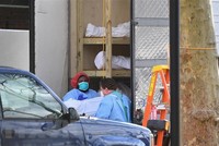 Nhân viên y tế chuyển thi thể bệnh nhân COVID-19 từ một nhà xác dã chiến tới Trung tâm y tế Do thái Kingsbrook ở Brooklyn, New York, Mỹ. (Ảnh: AFP/TTXVN).