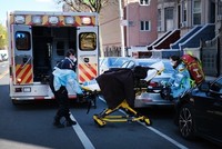 Nhân viên y tế di chuyển một bệnh nhân lên xe cứu thương ở New York ngày 11/4. Ảnh: AFP.