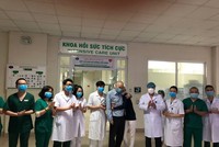 Vợ chồng ông Dixong (mặc áo bệnh nhân/áo đen) và các nhân viên y tế Bệnh viện Bệnh nhiệt đới trung ương tối 13-4, trước khi ông bà ra viện và về nước. (Ảnh: Bệnh viện Bệnh Nhiệt đới Trung ương cung cấp).