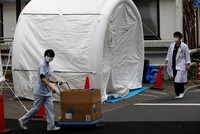 Nhân viên y tế bước qua một chiếc lều dùng để xét nghiệm nCoV tại bệnh viện đa khoa Kawakita ở Tokyo, Nhật Bản, ngày 17/4. Ảnh: Reuters.