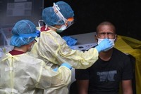 Nhân viên y tế xét nghiệm một lao động nhập cư tại Singapore ngày 27/4. Ảnh: AFP.