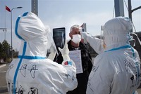 Nhân viên y tế Trung Quốc kiểm tra thân nhiệt ngăn chặn sự lây lan của dịch COVID-19 tại một trạm kiểm tra hải quan ở Suifenhe, tỉnh Hắc Long Giang, gần biên giới với Nga, ngày 1/5/2020. (Ảnh: AFP/TTXVN).