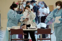 Hành khách đọc tài liệu do nhân viên y tế cung cấp khi tới sân bay Adolfo Suarez Barajas tại thủ đô Madrid, Tây Ban Nha, ngày 15/5. Ảnh: Reuters.