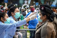 Nhân viên y tế kiểm tra thân nhiệt cho cảnh sát ở Bangkok, Thái Lan. (Nguồn: AFP/TTXVN).