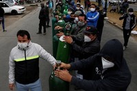 Người dân đeo khẩu trang xếp hàng chờ bên ngoài một cửa hàng phân phối oxy ở thủ đô Lima, Peru hôm 25/6. Ảnh: Reuters.