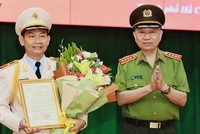 Đại tướng Tô Lâm thừa uỷ quyền của Chủ tịch nước trao quyết định và tặng hoa chúc mừng Thiếu tướng Đinh Thanh Nhàn.