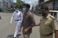 Cảnh sát Ấn Độ bắt một người đàn ông (giữa) vi phạm lệnh phong tỏa ngăn Covid-19 tại thành phố Siliguri, bang Tây Bengal hôm 25/7. Ảnh: AFP.