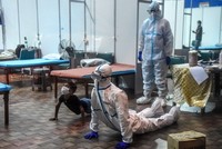 Nhân viên y tế và một bệnh nhân Covid-19 nhỏ tuổi thực hiện động tác yoga tại một bệnh viện Ấn Độ. Ảnh: AFP.