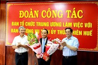 Trưởng ban Tổ chức Trung ương Phạm Minh Chính (bìa phải) và Bí thư Tỉnh ủy Thừa Thiên Huế Lê Trường Lưu (bìa trái) tặng hoa chúc mừng ông Nguyễn Quốc Đoàn.