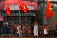 Người dân ở trên tuyến đường Nguyễn Thị Minh Khai vui mừng sau khi hoàn thành cách ly 14 ngày trong khu vực phong tỏa. (Ảnh: Trần Lê Lâm/TTXVN).