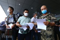 Công dân nhận giấy ra viên trước khi trở về nhà. (Ảnh: Minh Quyết/TTXVN).