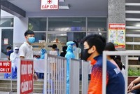 Người dân đến lấy mẫu xét nghiệm được bố trí ngồi chờ theo khu vực quy định. (Ảnh: Minh Quyết/TTXVN).