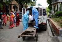 Các nhân viên y tế di chuyển thi thể một người chết vì nCoV tại New Delhi, Ấn Độ, hôm 22/8. Ảnh: Reuters.