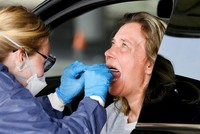 Nhân viên y tế lấy mẫu xét nghiệm nCoV tại một trạm kiểm tra trong xe ôtô ở Alkmaar, Hà Lan, hồi tháng 4. Ảnh: Reuters.