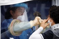 Người phụ nữ được lấy mẫu xét nghiệm nCoV tại một phòng khám dã chiến ở Seoul, Hàn Quốc, ngày 26/8. Ảnh: Reuters.