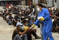 Tình nguyện viên phát thức ăn cho người dân tại khu vực bị áp hạn chế ngăn Covid-19 ở Kathmandu, Nepal hôm 31/8. Ảnh: AFP.