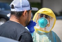 Nhân viên y tế tại hạt Fresno, bang California, Mỹ, lấy mẫu xét nghiệm nCoV cho một người dân ngày 8/8. Ảnh: Reuters.