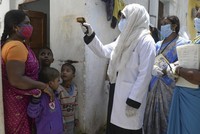 Nhân viên y tế kiểm tra thân nhiệt người dân ở thành phố Hyderabad, Ấn Độ, hôm 24/9. Ảnh: AFP.
