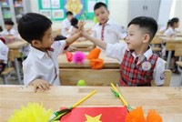 Học sinh lớp 1 trường Tiểu học Thăng Long, quận Hoàn Kiếm bày tỏ sự thích thú với môi trường học mới. (Ảnh: Thanh Tùng/TTXVN).