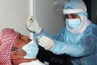 Nhân viên y tế lấy mẫu xét nghiệm nCoV tại sân bay quốc tế Muscat ở thủ đô Oman. Ảnh: AFP.