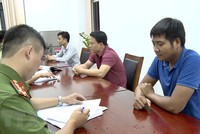 Lấy lời khai của nhóm đối tượng lừa đảo. (Ảnh: TTXVN phát).