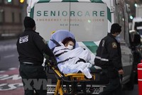Nhân viên y tế chuyển bệnh nhân COVID-19 tới bệnh viện ở New York, Mỹ. (Ảnh: THX/TTXVN).