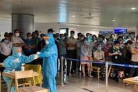 Nhân viên y tế làm thủ tục lấy mẫu xét nghiệm cho người làm việc tại sân bay Tân Sơn Nhất. (Ảnh: TTXVN phát).