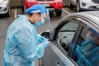 Nhân viên y tế lấy mẫu xét nghiệm COVID-19 cho người dân tại Auckland, New Zealand. (Ảnh: AFP/TTXVN).