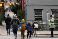 Học sinh tới lớp học sau khi trường học mở cửa trở lại tại New York , Mỹ. (Ảnh: AFP/TTXVN)