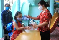 Đo thân nhiệt, rửa tay cho trẻ trước khi vào lớp. (Ảnh minh họa: Lê Thúy Hằng/TTXVN).