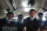 Những người Trung Quốc nhập cảnh trái phép bị phát hiện trong hầm xe. (Ảnh: TTXVN phát).