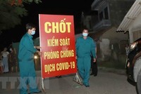 Lực lượng chức năng tiến hành tthu dọn vật dụng tại chốt cách ly tại thôn Tiền Phong, xã Tân Phong, huyện Bình Xuyên, Vĩnh Phúc. (Ảnh: Hoàng Hùng/TTXVN).