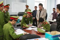 Lực lượng chức năng khám xét, thu giữ nhiều tài liệu liên quan đến sai phạm tại Ban Quản lý dự án Môi trường và Biến đổi khí hậu thành phố Đồng Hới.