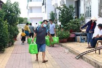 Chuyển nhu yếu phẩm đến cho người dân đang cách ly tại khu C, chung cư Văn Thánh, phường Phú Tài, thành phố Phan Thiết. (Ảnh: Nguyễn Thanh/TTXVN).