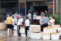 Nhân viên Siêu thị Ngọc Xuân dọn dẹp hàng hóa, đồ dùng sau vụ cháy. (Ảnh: Quốc Đạt/TTXVN).