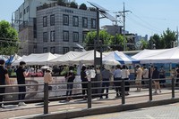 Người dân xếp hàng xét nghiệm COVID-19 trong thời tiết nắng nóng ở quận Seongbuk, Seoul. (Ảnh: Mạnh Hùng/TTXVN).