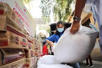 Hỗ trợ gạo và thực phẩm cho người dân gặp khó khăn do dịch COVID-19. (Ảnh: TTXVN).