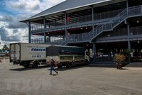 Các xe tải chờ làm thủ tục vào thành phố Cần Thơ giao nhận hàng hóa tại điểm kiểm soát ở Bến xe Trung tâm thành phố. (Ảnh: Thanh Liêm/TTXVN).