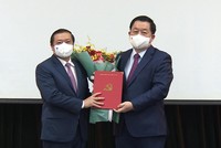 Ông Nguyễn Trọng Nghĩa trao quyết định và tặng hoa chúc mừng ông Lại Xuân Môn.