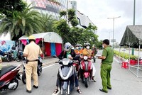 Lực lượng Công an tại chốt kiểm trên đường Phạm Văn Đồng (phường Hiệp Bình Chánh, Thủ Đức) kiểm tra giấy tờ của người lưu thông. (Ảnh: Thành Chung/TTXVN).