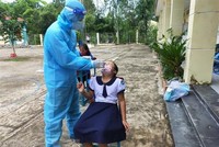 Lấy mẫu xét nghiệm COVID-19 cho học sinh, giáo viên tại Trường Tiểu học Thạnh An. (Ảnh: TTXVN phát).