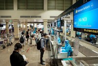 Hành khách Vietnam Airlines làm thủ tục ở quầy check-in sân bay Tân Sơn Nhất. (Ảnh: CTV/Vietnam+).