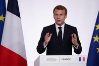 Tổng thống Pháp Emmanuel Macron bên cạnh quốc kỳ Pháp đã có thay đổi màu lam sáng thành lam đậm (Ảnh: AP).